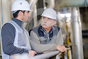 Chemical factory workers having talk