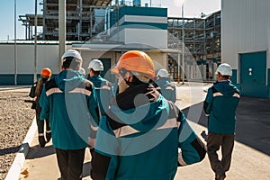 Chemical factory workers in working clothes walks to their workplaces