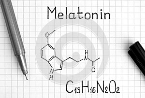 Chemical formula of Melatonin with black pen