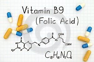 Chemical formula of Vitamin B9 Folic Acid with pills.