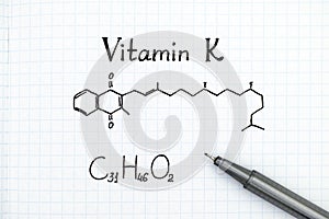 Chemical formula of Vitamin K with pen