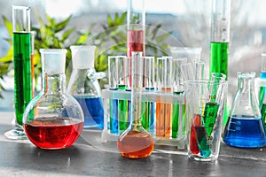 Chemical glassware with colorful samples on table
