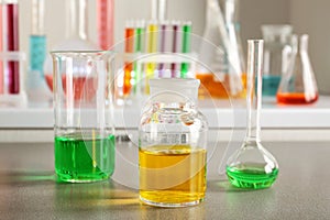 Chemical glassware with colorful samples on table in laboratory