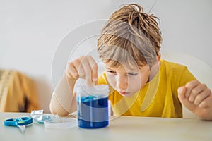 Chemical home tests. Tools for the home lab. the boy Explorer. Child is watching a chemical reaction. The young chemist