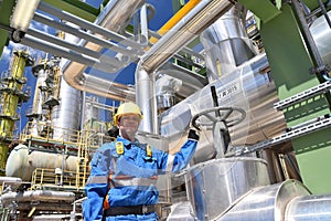 chemical industry plant - workers in work clothes in a refinery with pipes and machinery