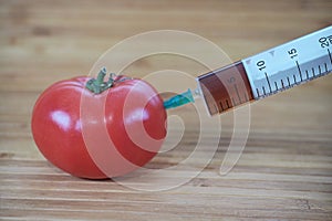 Chemical injection of tomato with syringe.