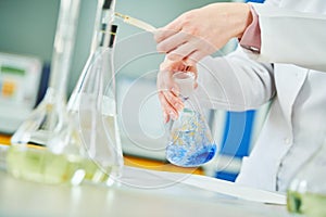 Chemical laboratory. Hand with flask during titrimetric analysis or titration