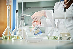 Chemical laboratory. Hand with flask during titrimetric analysis or titration