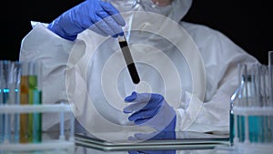 Chemical laboratory researcher examining test tube with naphtha, fuel quality