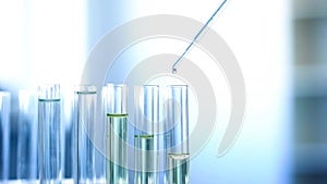 Chemical liquid dripping from pipette in lab tubes, checking reaction, research