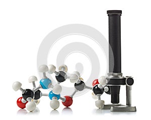 Chemical molecule model with old microscope over white background