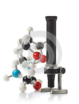 Chemical molecule model with old microscope over white background