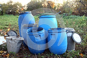 The blue plastic barrels for storage of chemicals . Stockpile of used blue plastic drums for storing water and other liquids