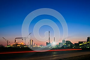 Chemical plant in a silhouette image at sunset, the glowing light of the chemical industry at sunset and twilight sky, the field