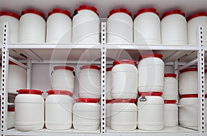 Chemical plastic barrels on shelves in storehouse