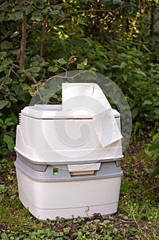 Chemical portable toilet. Single portable toilet standing on a green meadow