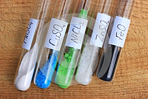Chemical reagents in test tubes: nickel chloride, zinc sulfate, manganese sulfate, copper sulfate, iron oxide of black color.