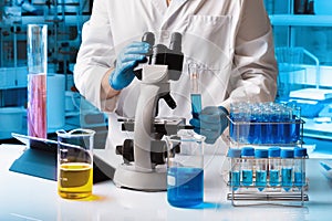 Chemical researcher working in research lab with material and microscope
