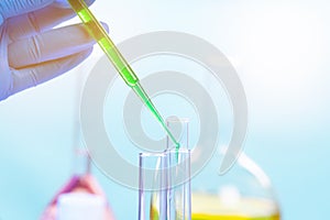 Chemical test tubes and pipette with green liquid close up in a chemical laboratory
