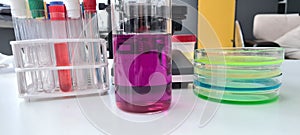 Chemical violet aqueous solution in glass flask in blue educational science laboratory