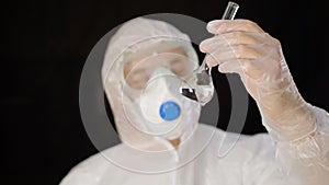 Chemical worker in protective costume looking clean water in lab tube isolated on white background. Bioengineer checking