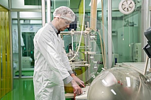 Scientist apothecary extract using cannabis extraction machine in laboratory.