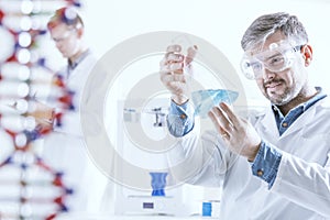Chemist holding glass vessel