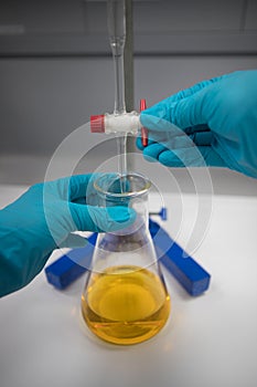 Chemist in a laboratory analysing a sample by titration