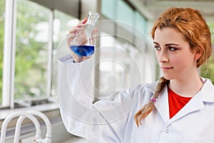 Chemist looking at a blue liquid