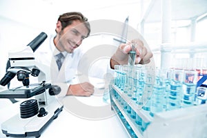 Chemist looking at test-tubes with blue liquids