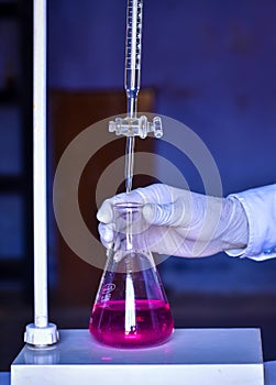 The chemist measures with precision in acid-base titration, adding solutions until neutralization