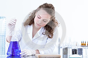 Chemist mixing blue solution