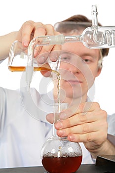 Chemist pours brown liquid in flask