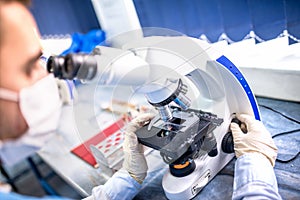 Chemist researcher working with microscope for forensic evidence