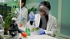 Chemist scientist african woman taking dna solution from test tube
