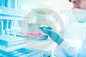 Chemist scientist holding sample and examining test tube in special laboratory