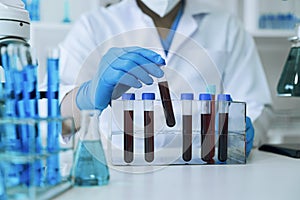 Chemist scientist holding test tube and tablet conducting experiment in laboratory with equipment, science concept