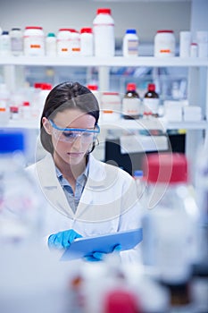 Chemist wearing safety glasses and using tablet pc