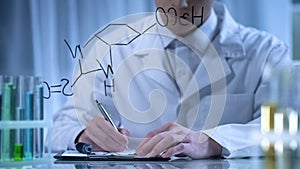 Chemist writing formula on glass and cardboard folder, research in cosmetology