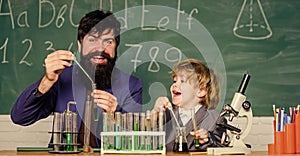 Chemistry beaker experiment. bearded man teacher with little boy. Laboratory test tubes and flasks with liquids father