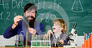 Chemistry beaker experiment. bearded man teacher with little boy. Laboratory test tubes and flasks with liquids father