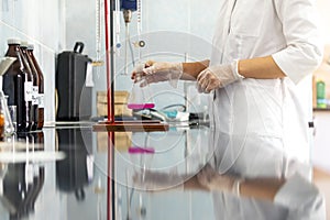 Chemistry expert is working with solutions and test tubes on the workbench in a chemistry laboratory.