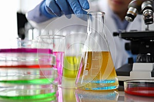 Female chemist in blue protective gloves hand hold test tube photo