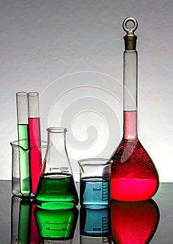 Chemistry laboratory beakers ,and test tubes on a reflecting surface and periodic table background