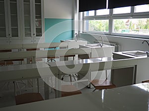 Chemistry room in a modern new school. Beautiful white furniture with sinks and washbasins. Large windows with blackout