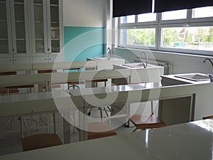 Chemistry room in a modern new school. Beautiful white furniture with sinks and washbasins. Large windows with blackout