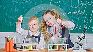 At chemistry school. School children performing experiment in science classroom. Schoolgirls holding test tubes. Science