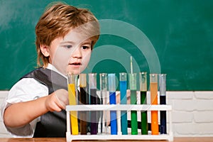 Chemistry science. First school day. Happy little scientist making experiment with test tube. Learning at home. Lab