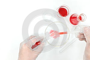 Chemistry science research laboratory flat lay. Scientist hands working on red chemicals.