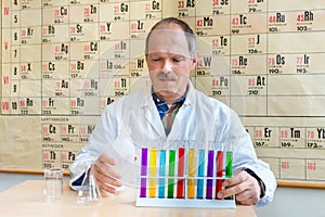 Chemistry teacher filling colorful test tubes